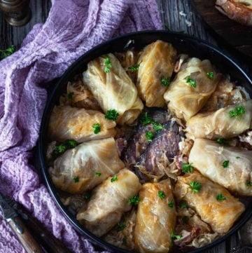 Overhead photo of a plate with rolls on a wooden table with purple napkin.