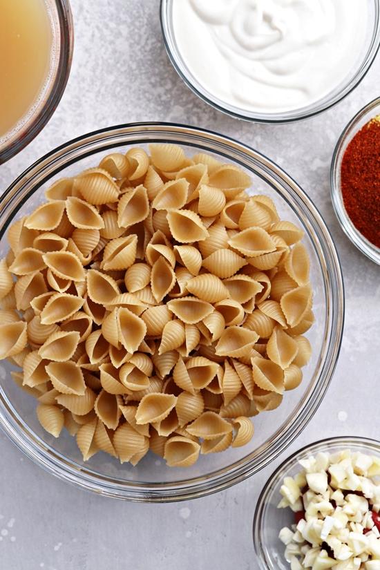 Dry pasta, spices and broth in small bowls.