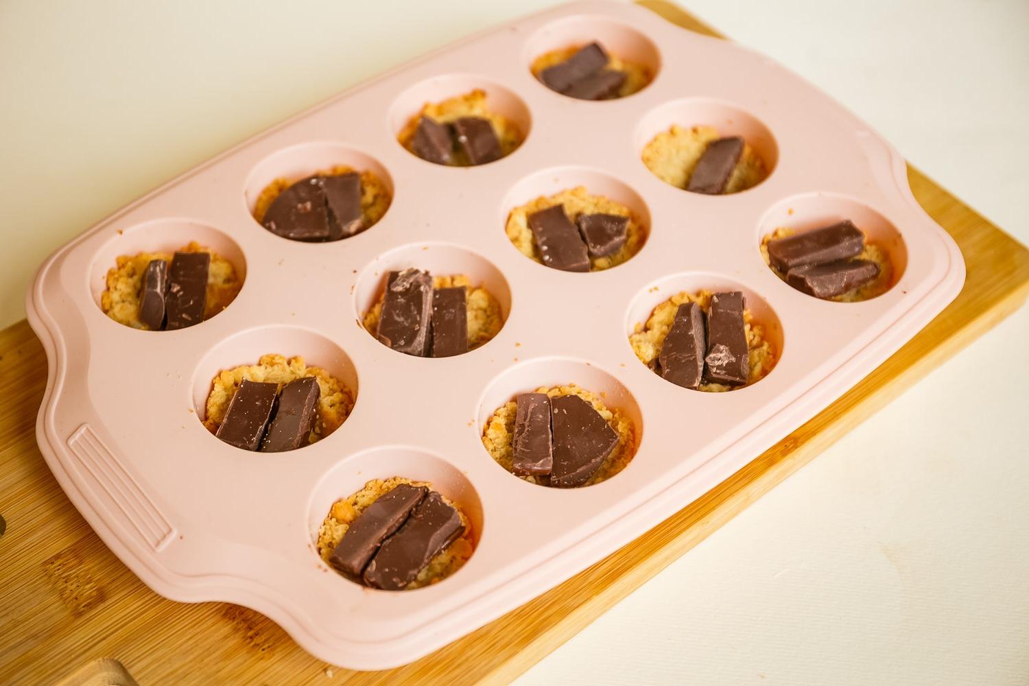chocolate on top of a graham cracker crust in muffin tins