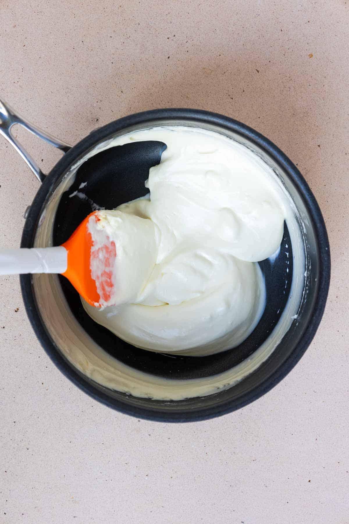 The cream cheese and heavy cream are warmed through in a medium saucepan until the cream cheese is melted and smooth.