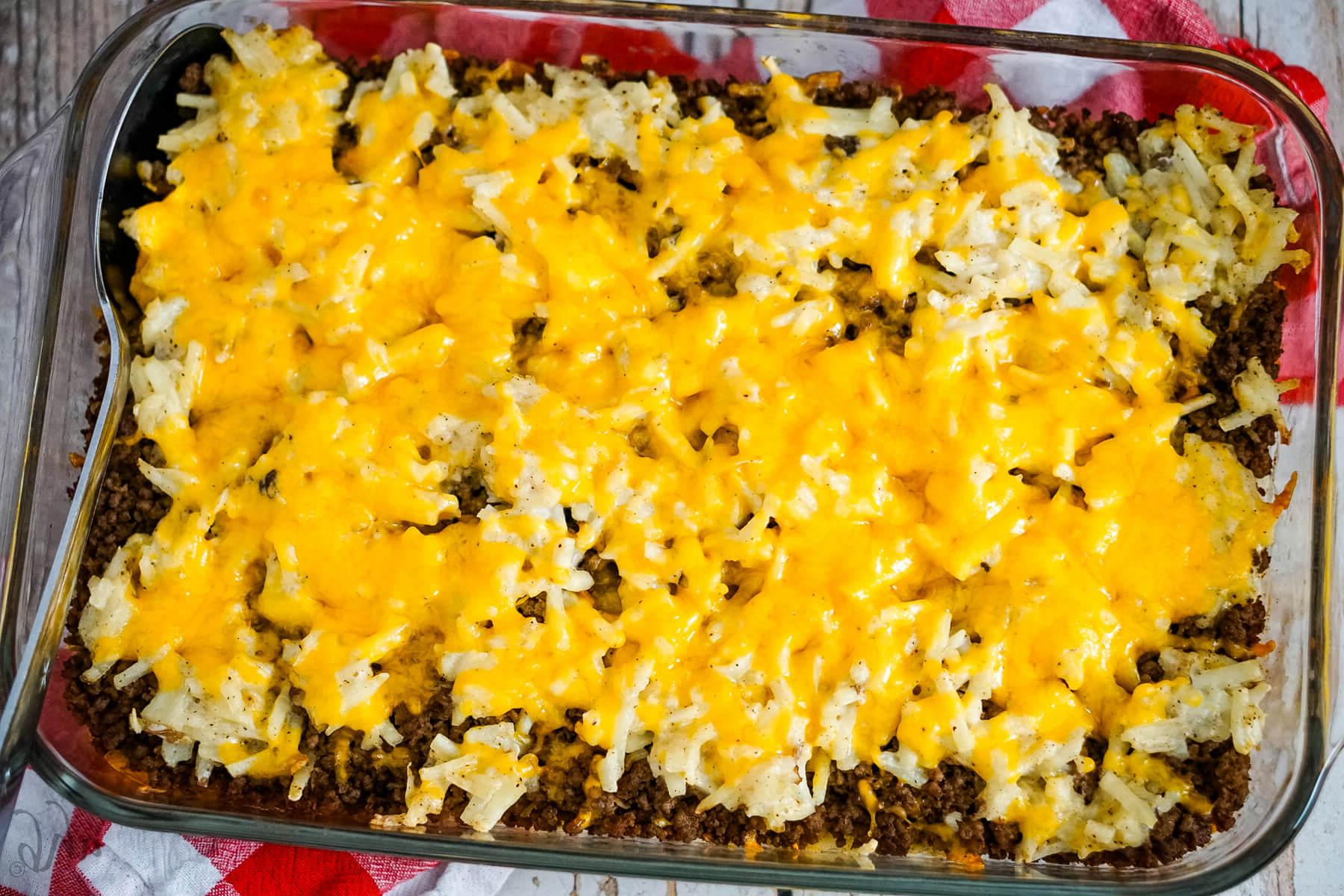 A pan of Hamburger Hashbrown Casserole with a spoon to one side.