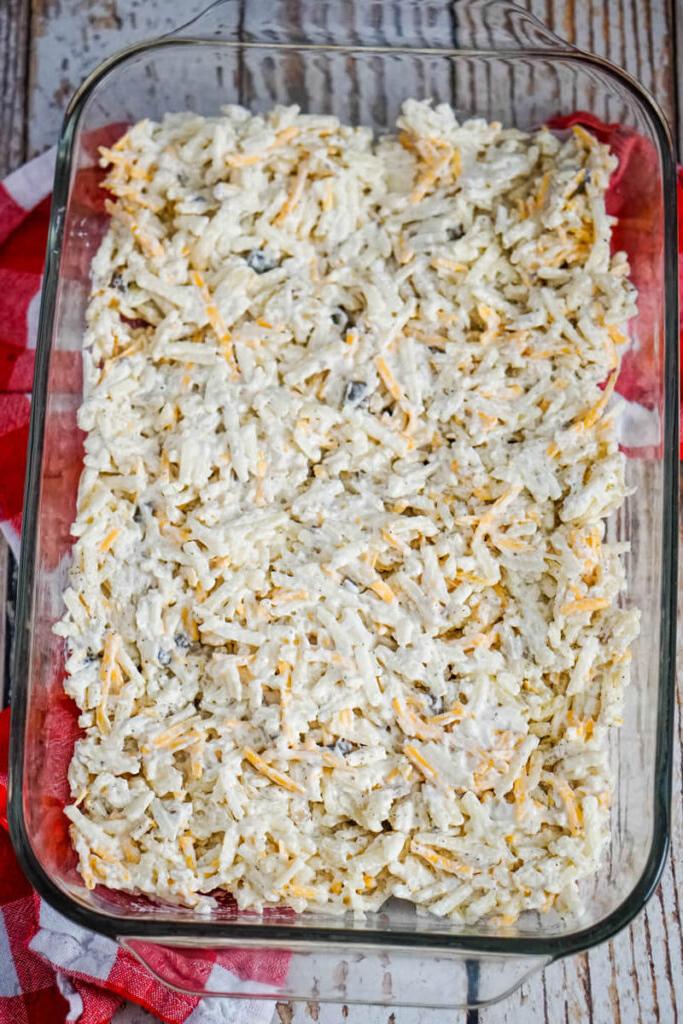 A layer of the potato mix is spread evenly in a 9x13 casserole dish.