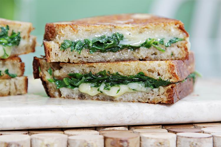 Sarımsaklı şekerleme ve rucola ile ızgara peynirli sandviç.