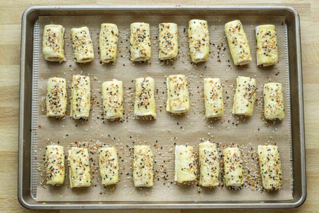 Baking sheet with puff pastry pigs in a blanket ready to bake.